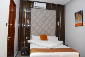 a bedroom with two beds and a headboard at Grand Seasons Hotel, Nnewichi in Nnewi