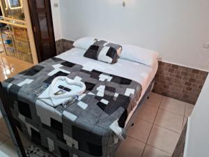 Una cama con un edredón blanco y negro. en Hotel Kamelot Parque Central, en Quetzaltenango