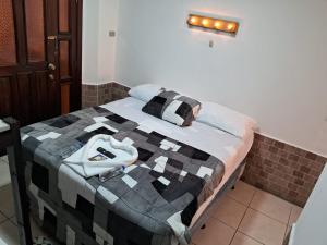 Una cama con edredón en una habitación en Hotel Kamelot Parque Central, en Quetzaltenango