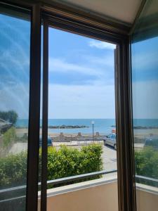 uma vista para a praia a partir de uma janela em Tropical House em Formia