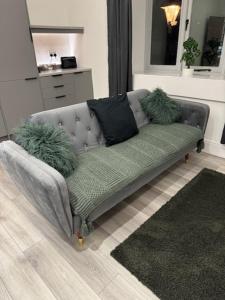 a couch in a living room with pillows on it at Mood Apartment 4 in Bedlington