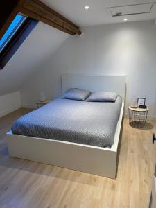 a bedroom with a bed in a white room at La Petite Malouine in Dunkerque