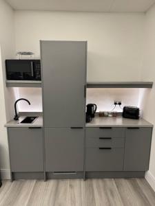 a kitchen with a white cabinet and a microwave at Mood Apartment 4 in Bedlington