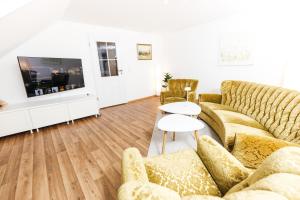 sala de estar con 2 sofás y TV en HEIMATEL - Ferienwohnung Bräuhaus en Scheidegg