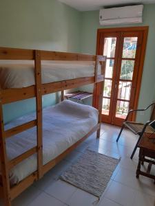 Un dormitorio con dos literas y una ventana. en Casa Adelfas, Benajarafe, en Benajarafe