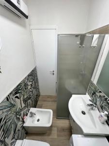 La salle de bains est pourvue d'un lavabo, de toilettes et d'une douche. dans l'établissement 5 TERRE EXPRESS MIGLIARINA, à La Spezia