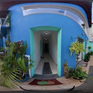 a blue building with a hallway with plants at Pousada Caminho do Mar in Paraty