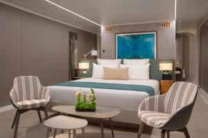 a bedroom with a bed and two chairs and a table at Dreams Curacao Resort, Spa & Casino in Willemstad