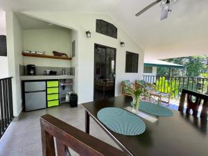 a dining room with a table and a kitchen at Jungle Passion Lodge in Ojochal