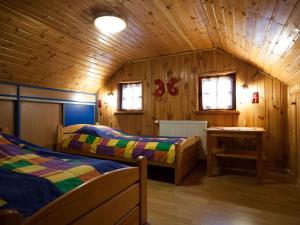 a bedroom with two beds in a wooden cabin at Four -anniversary Type B in Dźwirzyno