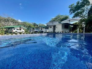 a large blue swimming pool in front of some houses at Jungle Passion Lodge in Ojochal