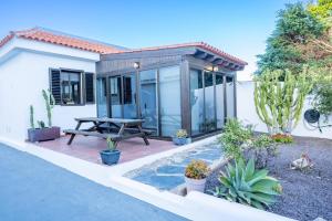 a house with a patio with a picnic table and cactus at Casa Lula in El Médano