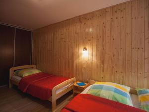 two beds in a room with wooden walls at Holiday apartment four seasons in Dźwirzyno