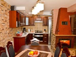 a kitchen with a dining table and a fireplace at Holiday apartment four seasons in Dźwirzyno