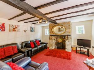 a living room with leather furniture and a stone fireplace at 4 Bed in Dartmoor National Park 49535 in Sampford Courtenay
