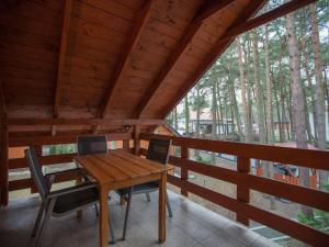 a wooden table and chairs on the porch of a cabin at Four -anniversary Type C in Dźwirzyno