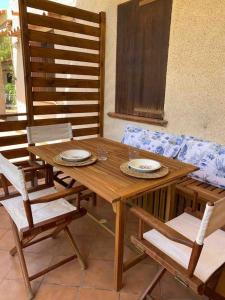 a wooden table and chairs with plates on it at Casa a schiera - CÀ MELJ in Rena Majore +15 photos