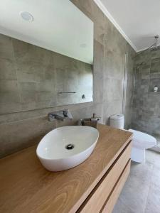 y baño con lavabo blanco y aseo. en Casa de campo familiar, Puerto Varas Chile, en Llanquihue
