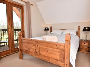 a bedroom with a wooden bed and a balcony at 3 Bed in Ledbury 77379 