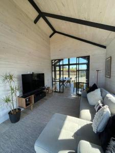 a living room with a couch and a tv at Casa de campo familiar, Puerto Varas Chile in Llanquihue