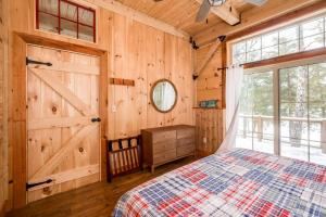 a bedroom with a bed and a wooden wall at Lake Winnipesaukee - Waterfront - 312 in Meredith