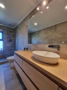 a bathroom with a large bowl sink on a wooden counter at Casa de campo familiar, Puerto Varas Chile in Llanquihue