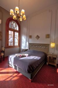 1 dormitorio con cama, ventana y lámpara de araña en Play Hostel Arcos en Buenos Aires