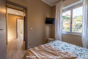 a bedroom with a bed and a large window at Casa Gelsomini by PortofinoVip in Santa Margherita Ligure