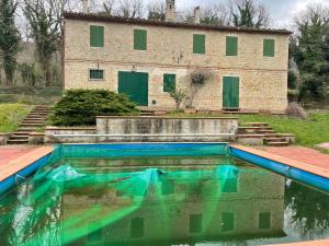 a pool of water in front of a building at Amico Country House in Serra San Quirico