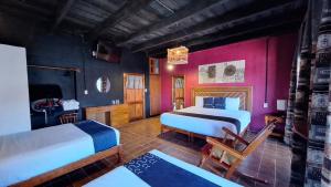 - une chambre avec 2 lits et des murs roses dans l'établissement Posada La Plazuela, à Cuetzalán del Progreso