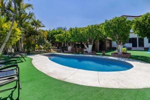 una piscina en un patio con sillas y árboles en QuintaRosita, en El Estudiante