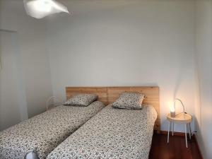 - une chambre avec deux lits et une table avec une lampe dans l'établissement Maison de ville CDG, Villepinte, à Juilly