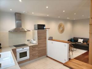 a kitchen and living room with a stove top oven at Maison de ville CDG, Villepinte in Juilly
