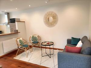 a living room with a couch and chairs and a table at Maison de ville CDG, Villepinte in Juilly