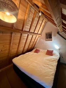 a bedroom with a bed in a room with wooden ceilings at Appartement centrum Delft in Delft