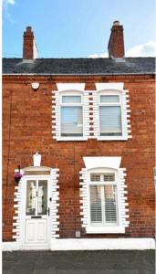 a brick house with white windows and a white door at Bloom19 Traditional Belfast house 10 mins from city centre in Belfast
