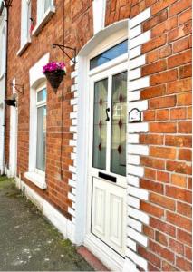 Una porta su un edificio di mattoni con un vaso di fiori sopra di Bloom19 Traditional Belfast Entire house 10 mins from city centre a Belfast