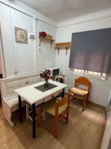 a room with a table and two chairs and a screen at Apartamento,Albares de la Ribera in Madrid