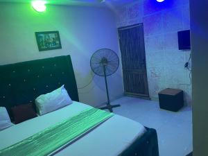 a bedroom with a bed and a fan at Nobles Hotel & Suites in Lagos
