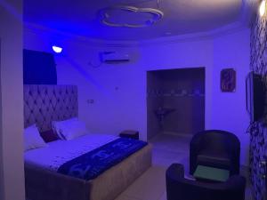 a purple room with a bed and a chair at Nobles Hotel & Suites in Lagos