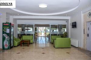 a lobby with green furniture in a building at Dikelya Hotel in Dikili