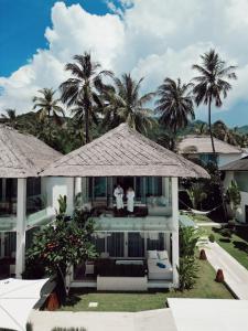 2 personnes debout sur le balcon d'une maison dans l'établissement Seven Secrets by Hanging Gardens, à Senggigi