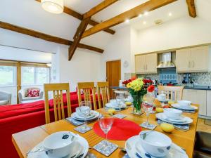 een eetkamer en een keuken met een houten tafel en stoelen bij 4 Bed in Abergavenny 90003 in Gilwern