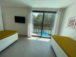 a bedroom with a large window with a view of a pool at Villa Pampelonne in São Martinho do Porto