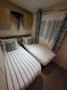 two beds sitting in a room with a window at 89 Main Park , Lilliardsedge in Harrietsfield