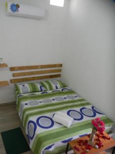 two twin beds in a room with a table at HostalNativo in Taganga