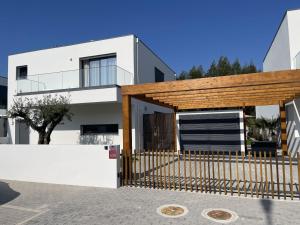 a white house with a gate and a fence at Villa Pampelonne in São Martinho do Porto