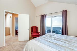 a bedroom with a bed and a chair and a window at Pismo Beach Condo with Balcony Near Wineries! in Pismo Beach