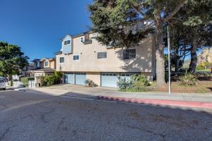 a building with two garage doors on a street at Pismo Beach Condo with Balcony Near Wineries! in Pismo Beach