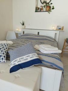 a bed with blue and white pillows on it at Casa Mamma Mia in Albori